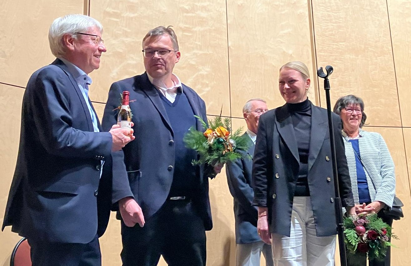 Personen mit Geschenken und Blumensträußen auf der Bühne